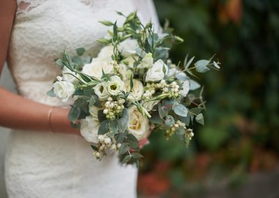 Bride holding a beautiful wedding bouquet of white roses.